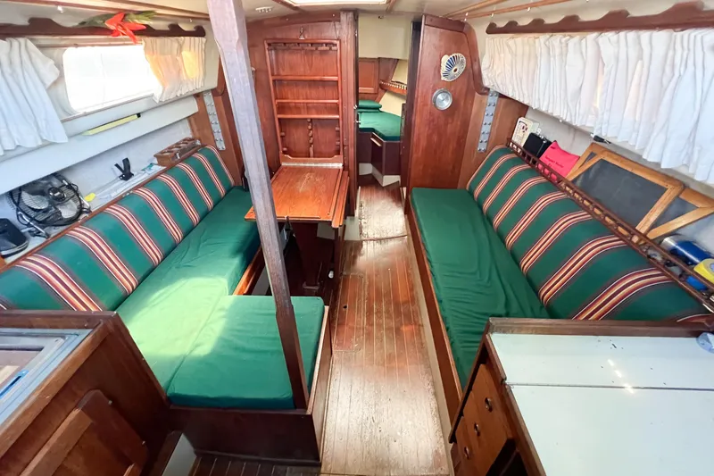 Slide: The Image of Interior of a 1978 CAL 34 sailboat with green-striped seating and wooden finishes. - 28