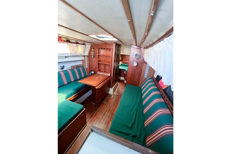 Slide: The Image of Interior of a 1978 CAL 34 sailboat with wooden furnishings and striped seating. - 30