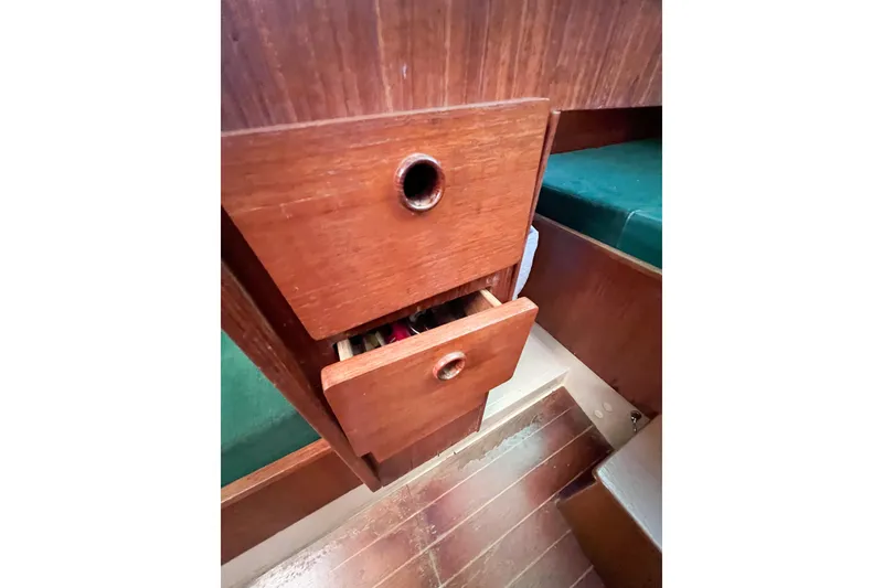 Slide: The Image of Wooden drawers in a 1978 CAL 34 boat interior, featuring green upholstery. - 32