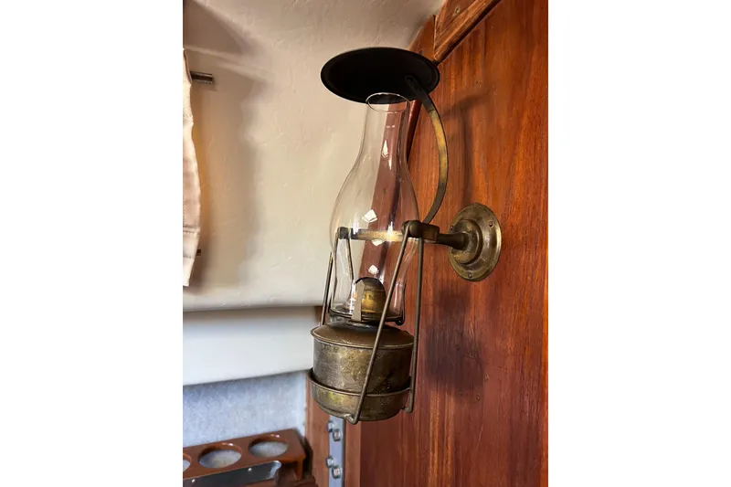 Slide: The Image of Vintage brass oil lamp mounted on wooden wall inside CAL 34, 1978 model. - 45