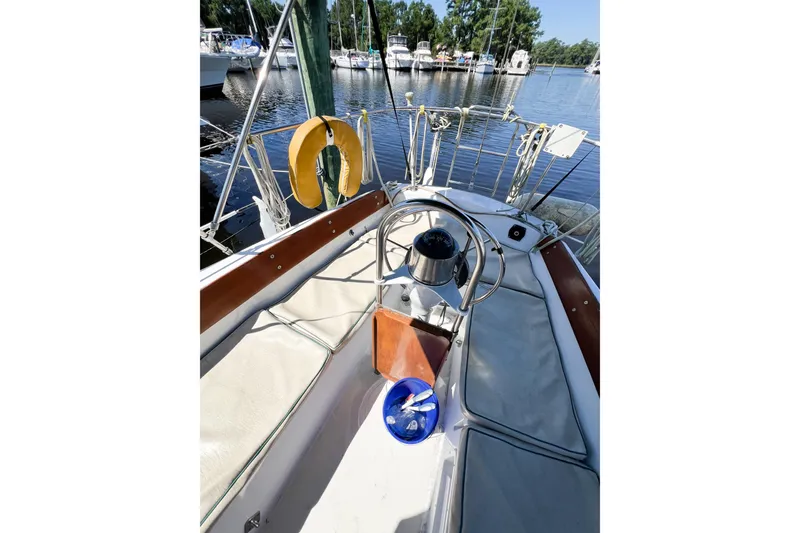 Slide: The Image of 1978 CAL 34 sailboat cockpit with steering wheel, docked at marina. - 48