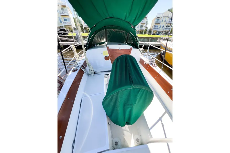 Slide: The Image of 1978 CAL 34 sailboat cockpit with green canopy and wooden accents at marina. - 6
