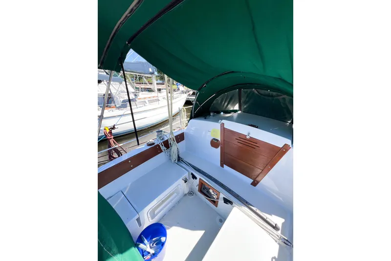 Slide: The Image of 1978 CAL 34 sailboat cockpit with green canopy and wooden accents at marina. - 7
