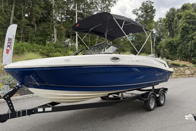 Slide: The Image of 2026 Bayliner VR6 Bowrider OB on trailer, blue hull, parked outdoors. - 11