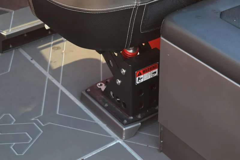 Slide: The Image of Stabicraft 2050 Treker Profish 2025 seat base with warning label and shock absorber. - 13