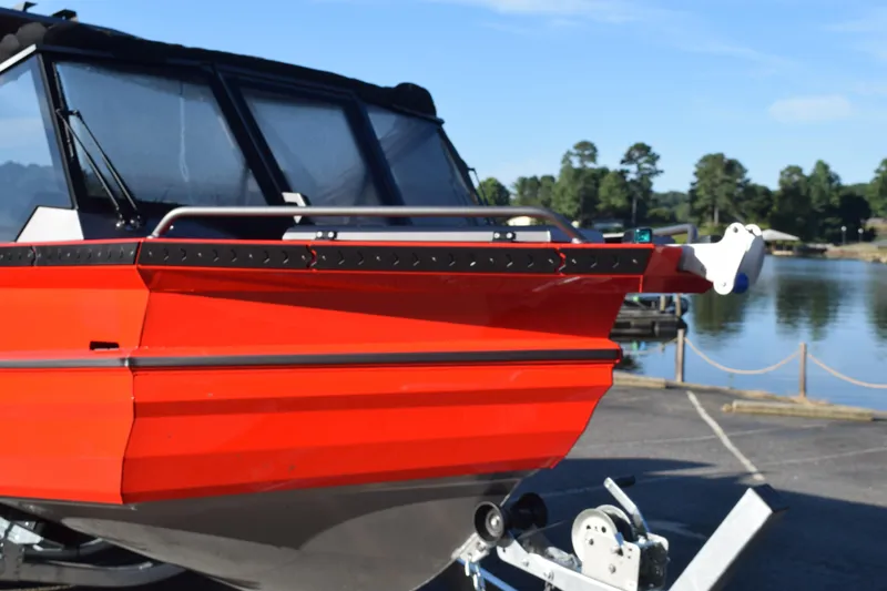 Slide: The Image of 2025 Stabicraft 2050 Treker Profish boat, vibrant red, docked by a serene lake. - 15