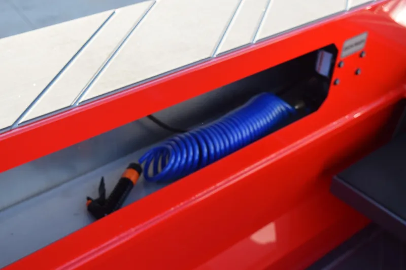 Slide: The Image of Red Stabicraft 2050 Treker Profish 2025 boat detail with coiled blue hose. - 17