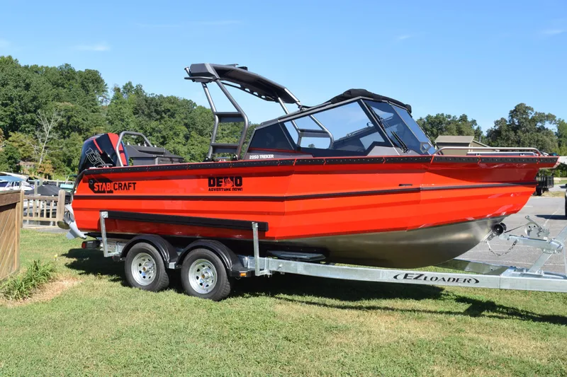 Slide: The Image of 2025 Stabicraft 2050 Treker Profish boat on trailer, vibrant red, parked on grass. - 2
