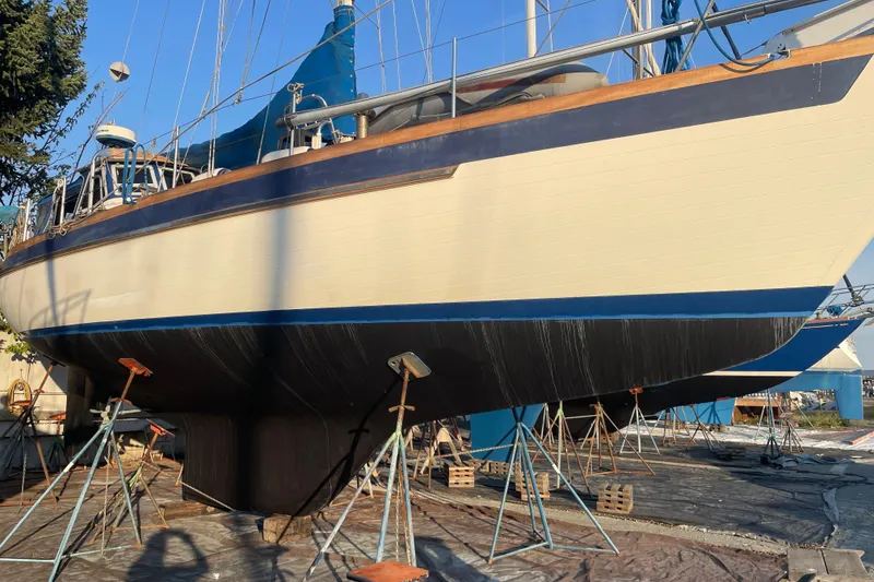 Slide: The Image of 1984 Slocum 43 sailboat on stands, undergoing maintenance in a boatyard. - 10
