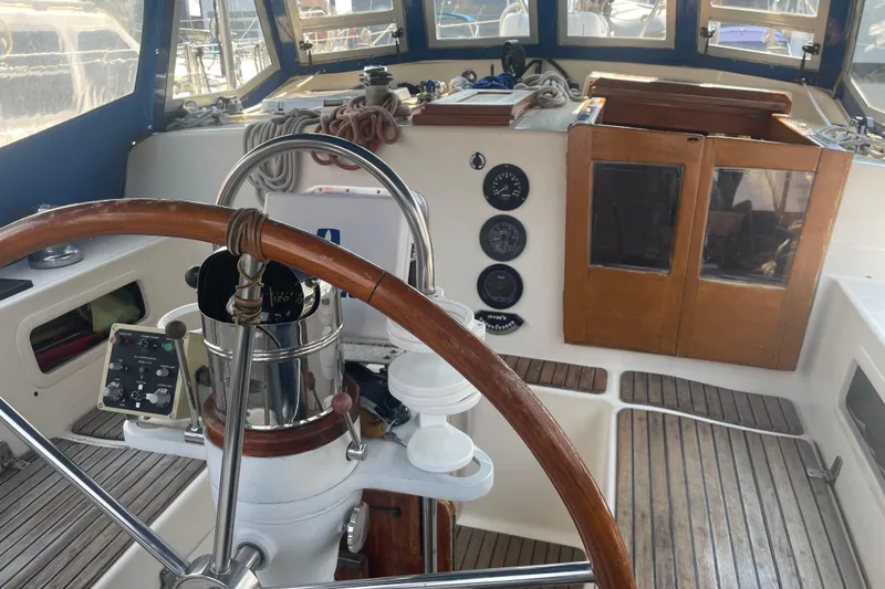 Slide: The Image of Interior view of a 1984 Slocum 43 sailboat cockpit with wooden steering wheel. - 11