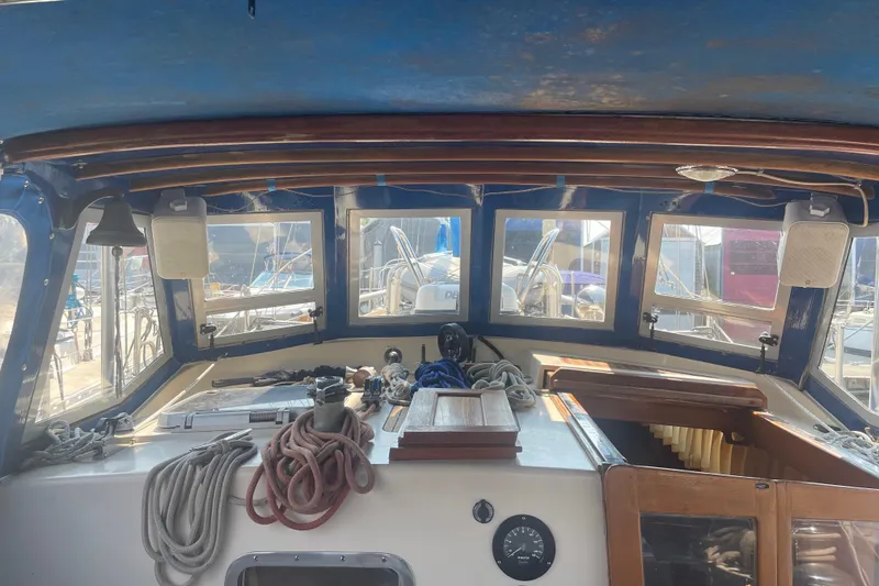 Slide: The Image of Interior view of a 1984 Slocum 43 sailboat cockpit with ropes and navigation equipment. - 14