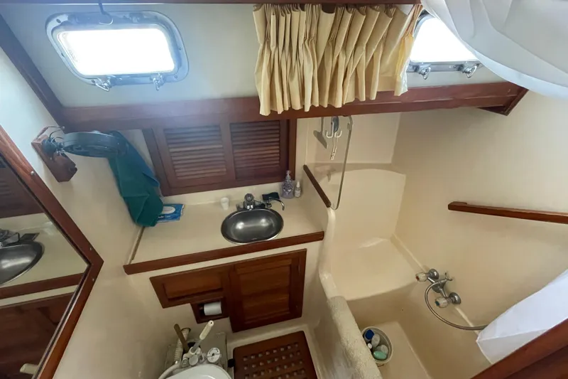 Slide: The Image of 1984 Slocum 43 yacht bathroom with sink, shower, and wooden cabinetry. - 18