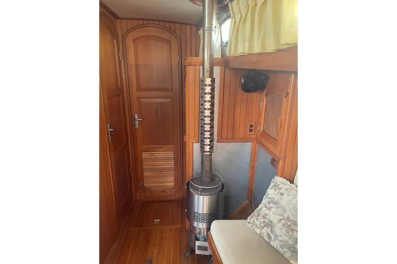 Slide: The Image of Interior of 1984 Slocum 43 sailboat with wood paneling and a metal stove. - 19