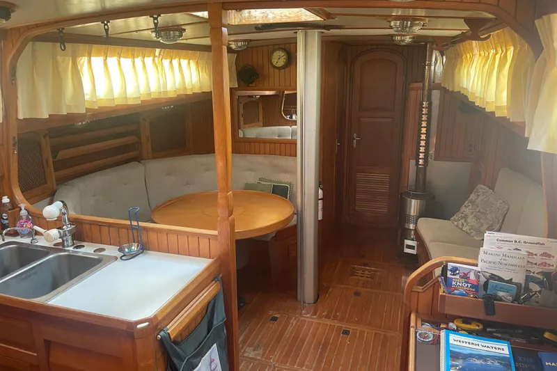 Slide: The Image of Interior of a 1984 Slocum 43 sailboat with wood finish and cozy seating area. - 20