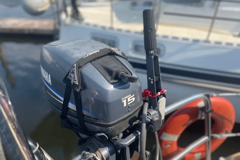 Slide: The Image of Outboard motor on a 1984 Slocum 43 sailboat, docked with lifebuoy visible. - 25