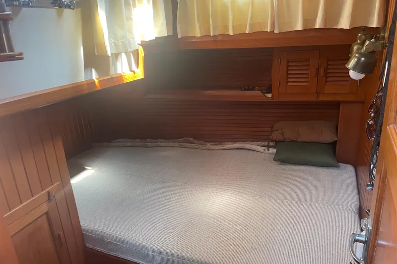 Slide: The Image of Cozy cabin interior of 1984 Slocum 43 sailboat with wooden paneling and bed. - 26