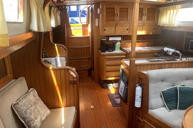 Slide: The Image of Interior of a 1984 Slocum 43 sailboat with wooden cabinetry and cozy seating. - 29