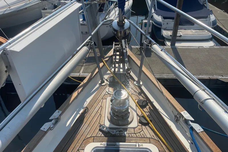 Slide: The Image of Bow of 1984 Slocum 43 sailboat docked, featuring deck details and mooring lines. - 4