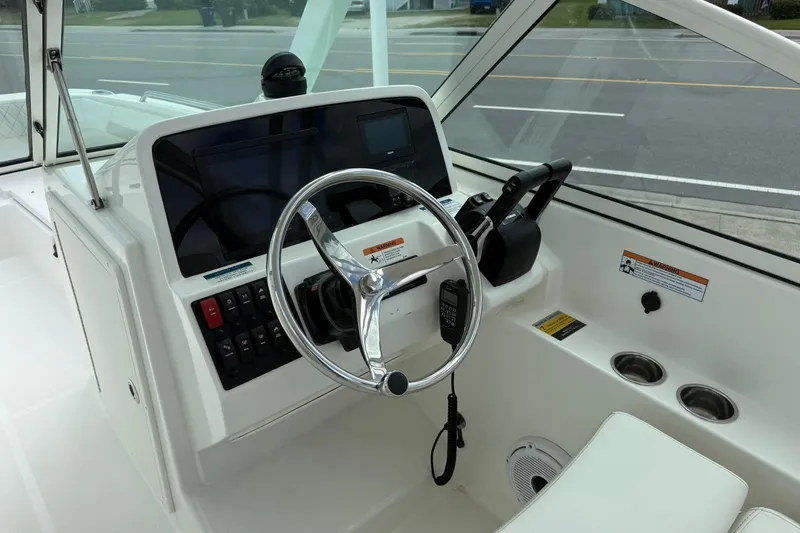 Slide: The Image of Helm of 2026 World Cat 230 DC boat with steering wheel and control panel. - 11