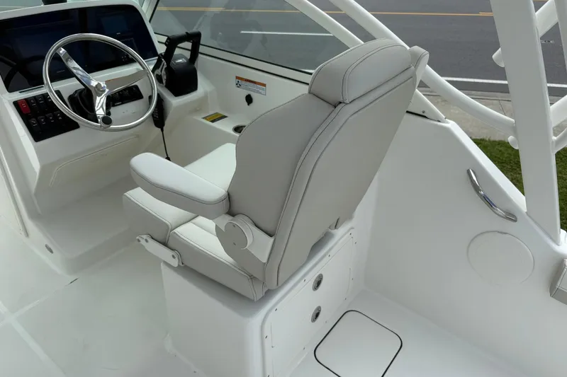 Slide: The Image of Helm of 2026 World Cat 230 DC boat with steering wheel and captain's chair. - 12
