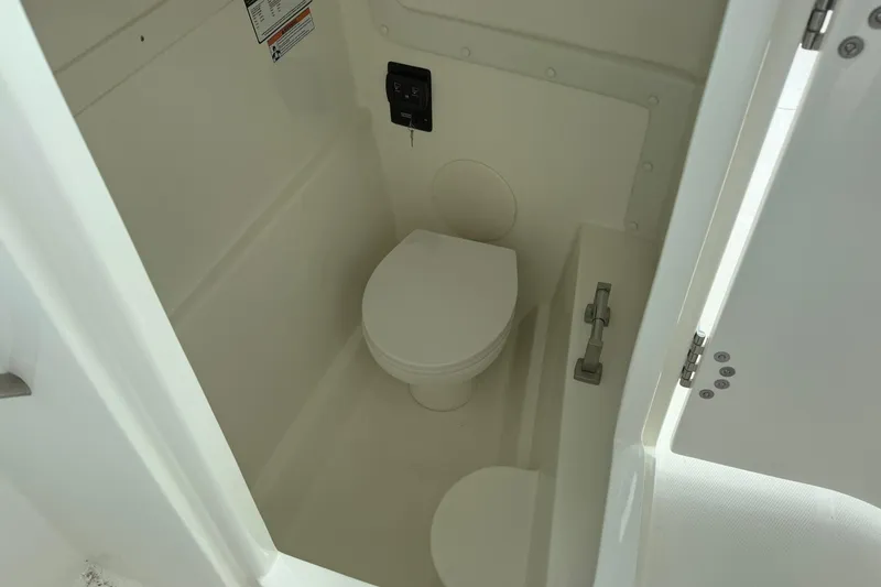Slide: The Image of 2026 World Cat 230 DC boat interior with compact marine toilet. - 15