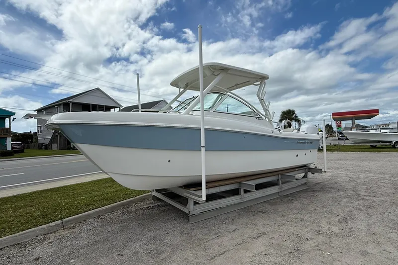 Slide: The Image of 2026 World Cat 230 DC boat on display under a cloudy sky. - 3