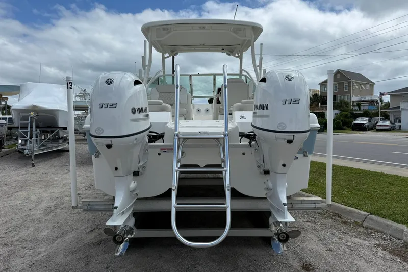 Slide: The Image of 2026 World Cat 230 DC boat with twin Yamaha 115 engines, docked outdoors. - 6