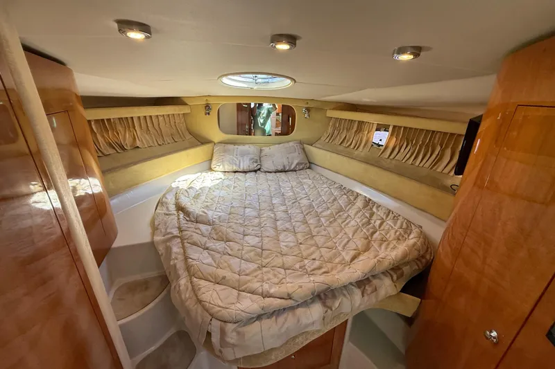 Slide: The Image of 2004 Regal Commodore 3860 cabin interior with cozy bed and elegant wood finishes. - 15