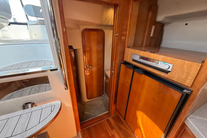 Slide: The Image of 2004 Regal Commodore 3860 yacht interior with wood cabinetry and compact kitchen area. - 18