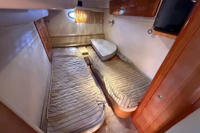 Slide: The Image of 2004 Regal Commodore 3860 cabin with twin beds and wooden cabinetry. - 21
