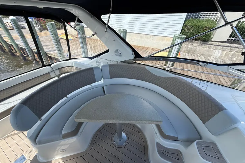 Slide: The Image of 2004 Regal Commodore 3860 yacht interior with curved seating and table, dockside view. - 5