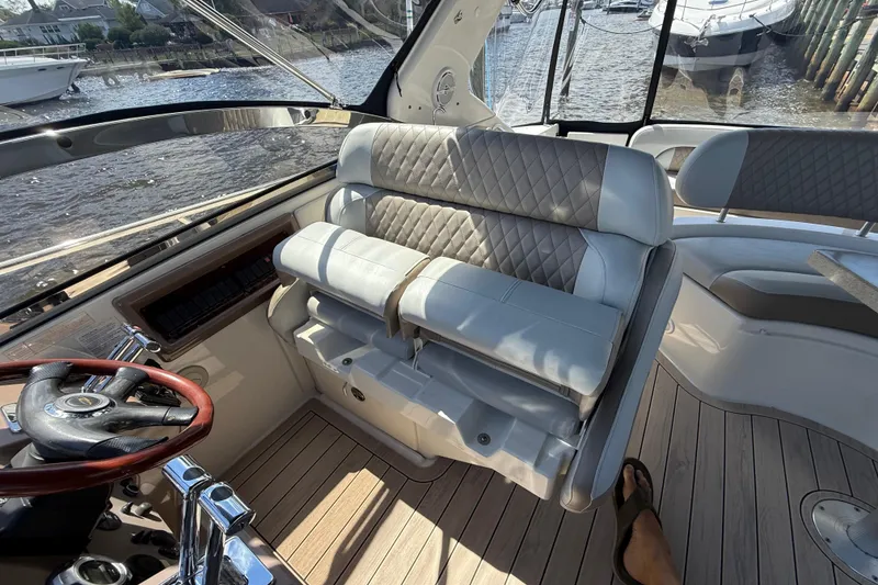Slide: The Image of 2004 Regal Commodore 3860 yacht interior with plush seating and steering wheel, docked by the water. - 7
