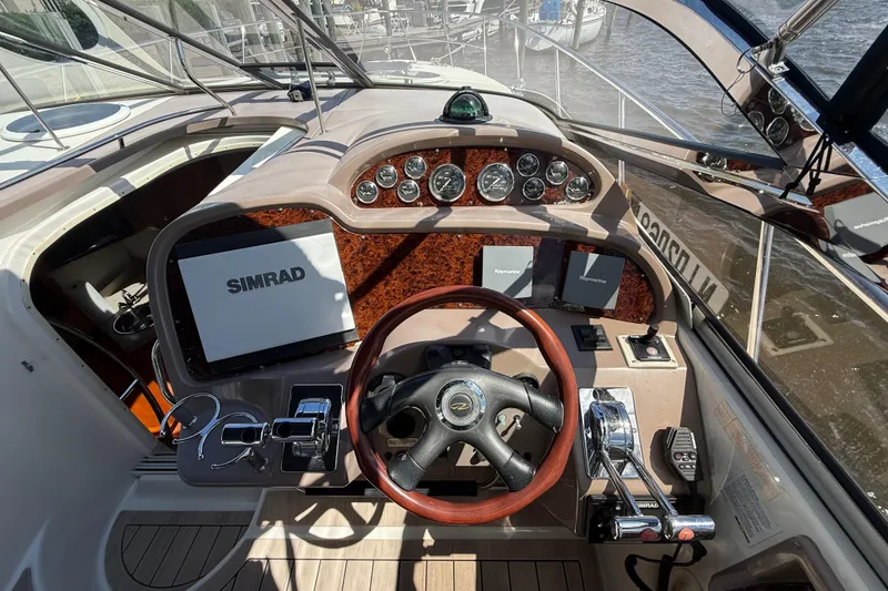 Slide: The Image of 2004 Regal Commodore 3860 helm with Simrad navigation, wood accents, and modern controls. - 8