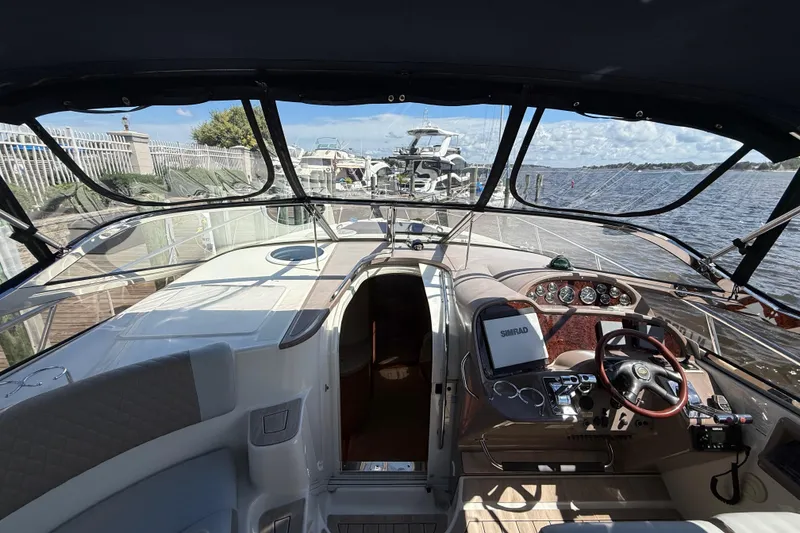 Slide: The Image of 2004 Regal Commodore 3860 yacht cockpit with steering wheel and navigation equipment, docked by the water. - 9