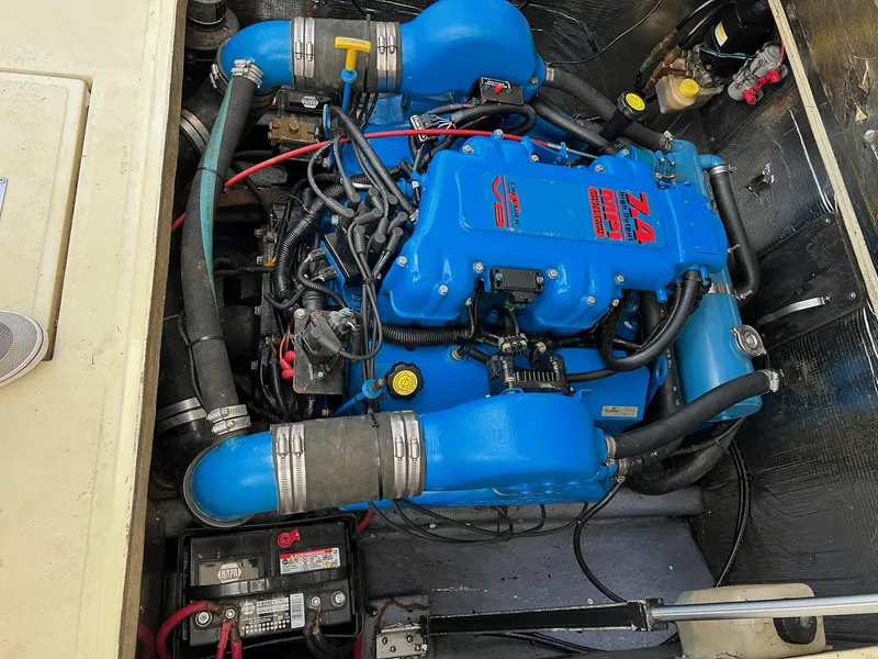 Slide: The Image of Engine compartment of a 2002 Carolina Classic 25 Classic boat, featuring a blue engine. - 12