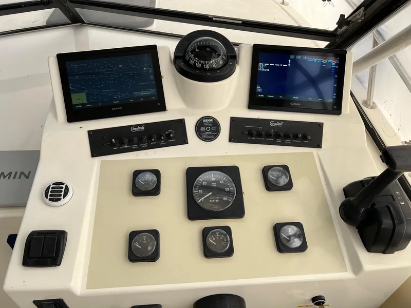 Slide: The Image of Control panel of a 2002 Carolina Classic 25 Classic boat with navigation screens and gauges. - 3