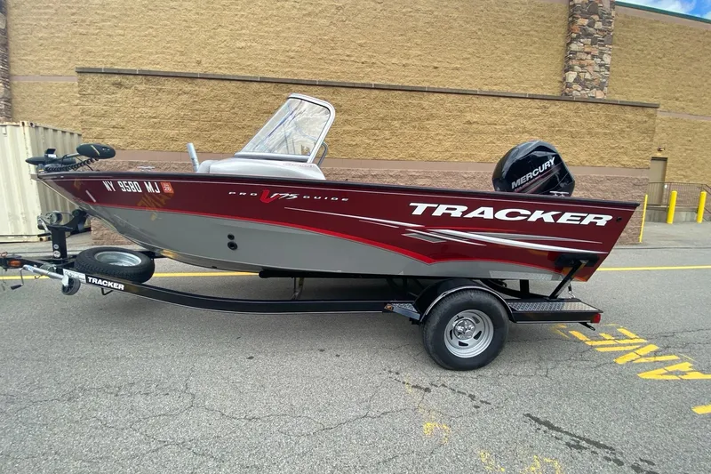 Slide: The Image of 2014 Tracker Pro Guide V-175 Combo boat on trailer, red and gray design, parked outdoors. - 2