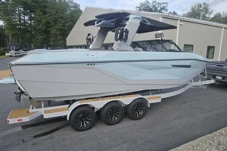 Slide: The Image of 2025 Nautique Super Air Nautique G23 boat on trailer, sleek design, parked outdoors. - 1