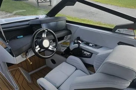 Slide: The Image of 2025 Nautique Super Air Nautique G23 interior with modern steering and seating design. - 12