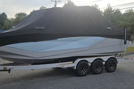 Slide: The Image of 2025 Nautique Super Air Nautique G23 boat on trailer, covered, parked outdoors. - 14