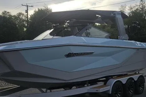 Slide: The Image of 2025 Nautique Super Air Nautique G23 boat on trailer, sleek design, parked outdoors. - 4