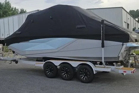Slide: The Image of 2025 Nautique Super Air Nautique G23 boat covered on a trailer, parked outdoors. - 5