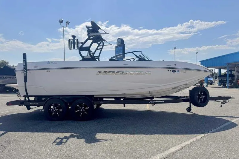 Slide: The Image of 2022 Moomba Mojo boat on trailer, parked outdoors under a clear sky. - 5