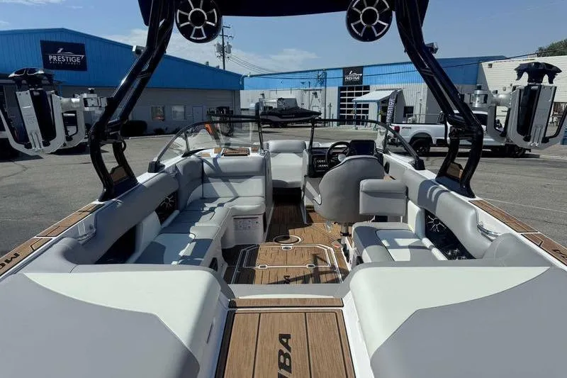 Slide: The Image of 2022 Moomba Mojo boat interior with seating and steering wheel, parked at a dealership. - 6