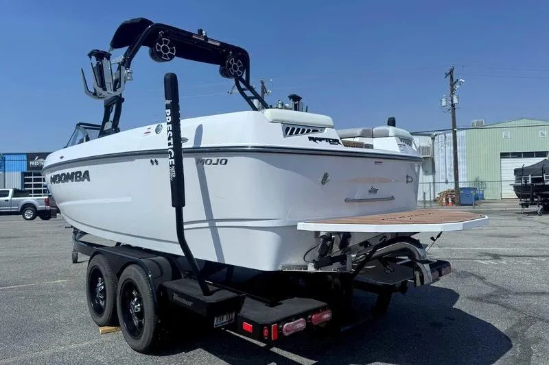 Slide: The Image of 2022 Moomba Mojo boat on trailer, parked outdoors, showcasing sleek design and dual-axle trailer. - 8