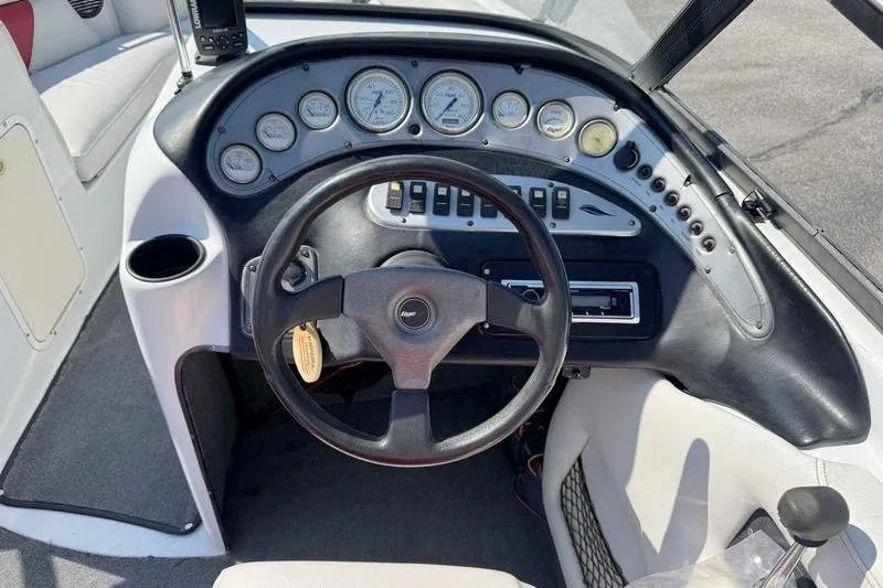 Slide: The Image of Dashboard of a 2000 Tigé 2300V Limited boat with gauges and steering wheel. - 12