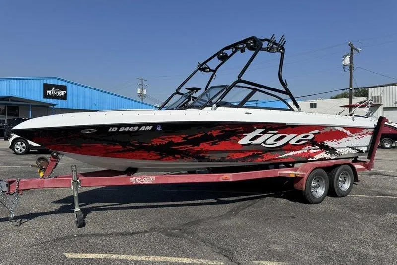 Slide: The Image of 2000 Tigé 2300V Limited boat on trailer, vibrant red and black design. - 7