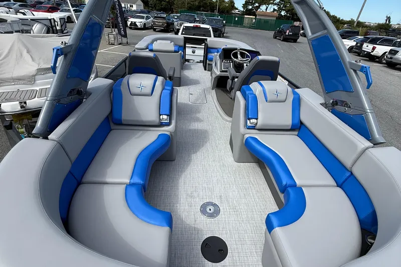 Slide: The Image of 2026 Berkshire 23RFX STS boat interior with blue and gray seating, parked outdoors. - 9