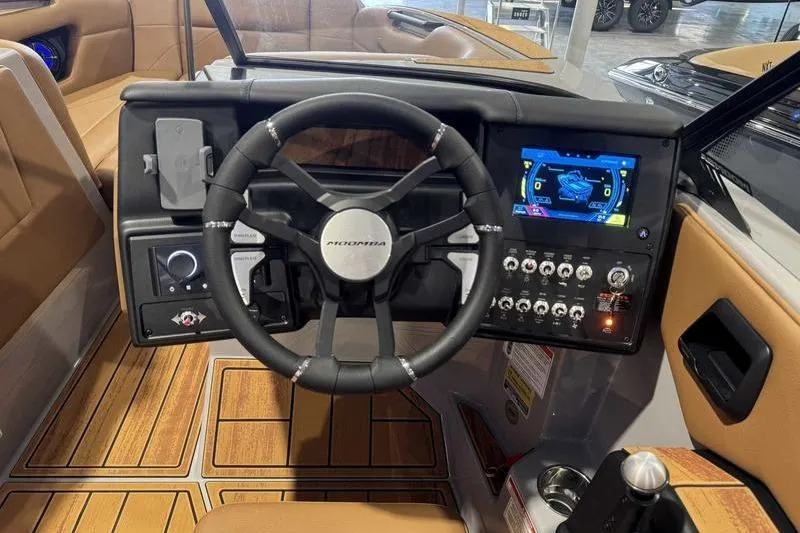 Slide: The Image of 2026 Moomba Mojo boat dashboard with steering wheel, touchscreen display, and control panel. - 10