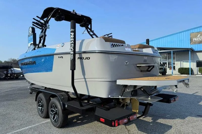 Slide: The Image of 2026 Moomba Mojo boat on trailer, blue and gray design, parked outdoors. - 5